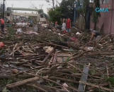 People walk on a flooded street filled with debris after Typhoon Haiyan hit the central Philippine city of Tacloban, Leyte province in this still image from video November 8, 2013. Typhoon Haiyan, possibly the strongest storm ever to hit land, has devastated Tacloban, killing at least 100 people and destroying most houses in a surge of flood water and high winds, officials said on Saturday. The toll of death and damage is expected to rise sharply as rescue workers and soldiers reach areas cut off by the massive storm, now barrelling out of the Philippines towards Vietnam. REUTERS/GMA News via Reuters TV (PHILIPPINES - Tags: DISASTER TRANSPORT ENVIRONMENT) ATTENTION EDITORS - THIS IMAGE WAS PROVIDED BY A THIRD PARTY. FOR EDITORIAL USE ONLY. NOT FOR SALE FOR MARKETING OR ADVERTISING CAMPAIGNS. NO SALES. NO ARCHIVES. THIS PICTURE IS DISTRIBUTED EXACTLY AS RECEIVED BY REUTERS, AS A SERVICE TO CLIENTS. PHILIPPINES OUT. NO COMMERCIAL OR EDITORIAL SALES IN PHILIPPINES. MANDATORY CREDIT TO GMA NEWS