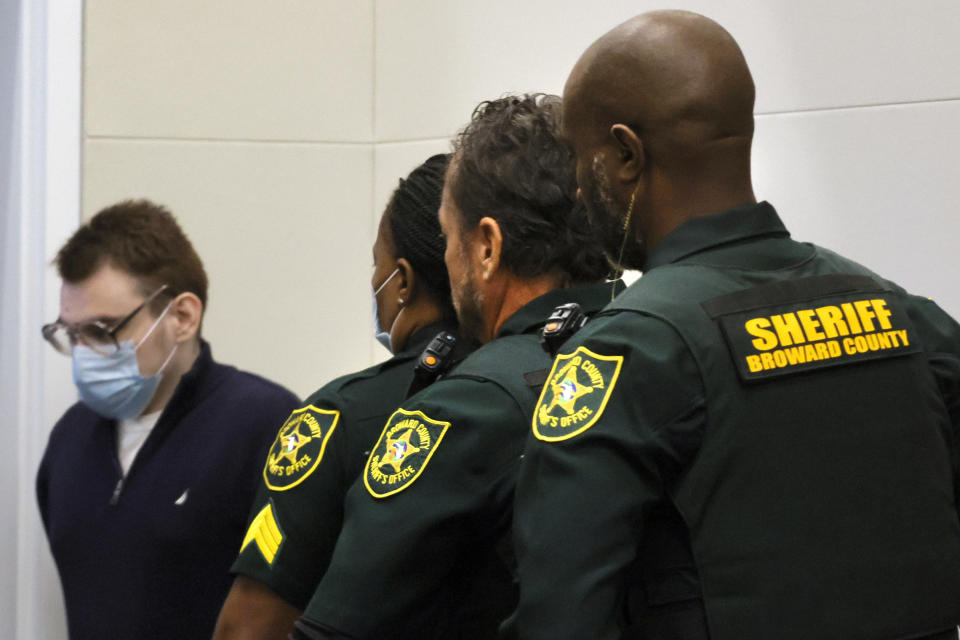 Nikolas Cruz is escorted out of the courtroom by Broward County Sheriff officers during the penalty phase of his trial at the Broward County Courthouse in Fort Lauderdale on Thursday, July 21, 2022. Cruz previously plead guilty to all 17 counts of premeditated murder and 17 counts of attempted murder in the 2018 shootings. (Mike Stocker/South Florida Sun Sentinel via AP, Pool)