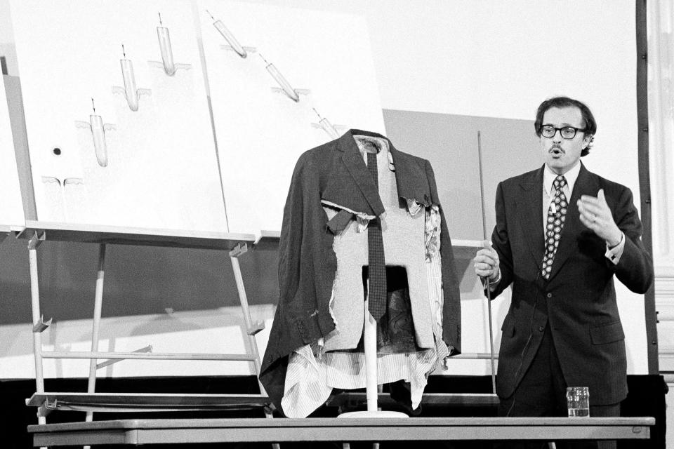 FILE - In this Sept. 7, 1978 file photo, Dr. Michael Baden, New York City's chief medical examiner, appears before the House Assassinations Committee in Washington, with the coat that President John F. Kennedy wore the day he was assassinated in Dallas, Texas. On Friday, Aug. 16, 2019, The Associated Press reported on stories circulating online incorrectly asserting that Baden performed Jeffrey Epstein’s autopsy in 2019. Epstein’s lawyers asked the well-known pathologist to attend the autopsy. He did not perform it. (AP Photo/John Duricka)