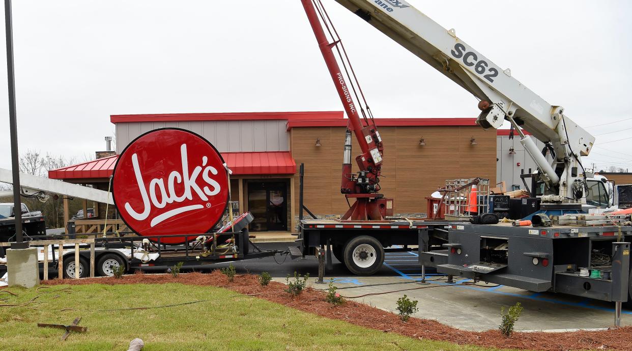 A work crew raises the sign for the new Jack's restaurant on University Blvd. in Alberta Friday, Feb. 25, 2022.