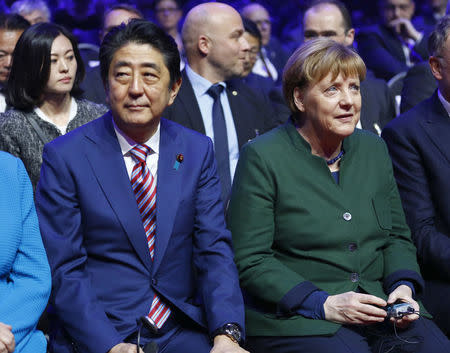 German Chancellor Angela Merkel and Japanese Prime Minister Shinzo Abe attend the opening ceremony of the CeBit computer fair, which will open its doors to the public on March 20, at the fairground in Hanover, Germany, March 19, 2017. REUTERS/Morris Mac Matzen