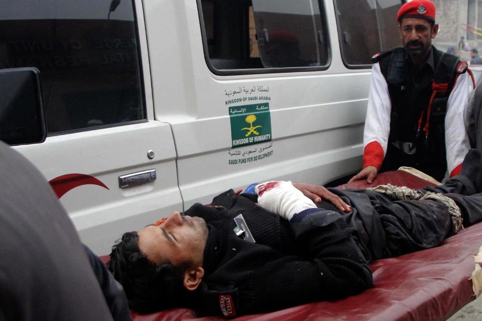 Staff shift an injured security officer to emergency ward at a hospital in Peshawar, Pakistan, Wednesday, Feb. 15, 2017. A Taliban suicide bombing targeted the administrative headquarters of a tribal region in northwestern Pakistan on Wednesday, killed scores of policemen and two passers-by, according to officials. (AP Photo/Mohammad Sajjad)