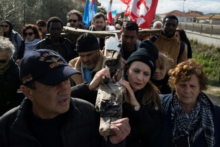 Unos manifestantes portan una cruz fabricada con los restos de la embarcación de migrantes naufragada, el 11 de marzo de 2023 en la localidad italiana de Steccato di Cutro (Gianluca Chininea)