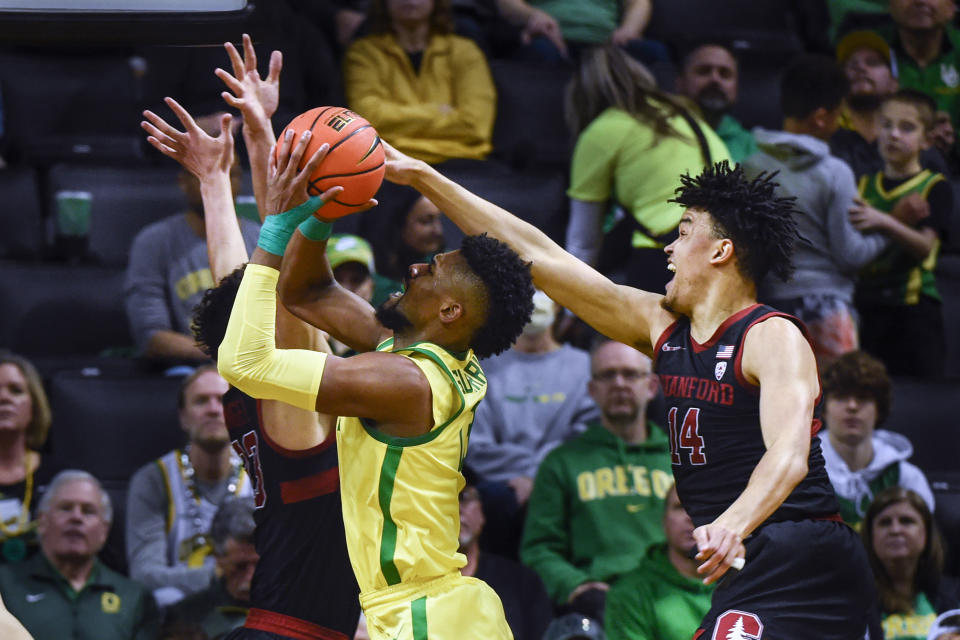 Oregon forward Quincy Guerrier, left, has his shot blocked by Stanford forward Spencer Jones (14) during the first half of an NCAA college basketball game Saturday, March 4, 2023, in Eugene, Ore. (AP Photo/Andy Nelson)