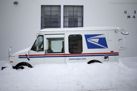 A U.S. Postal service delivery truck sits covered in snow outside the post office in Manhasset, New York January 27, 2015. REUTERS/Shannon Stapleton