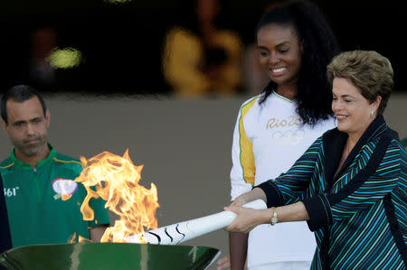 Brazil's President Dilma Rousseff (R) lights a cauldron with the Olympic Flame next to Fabiana Claudino, captain of the Brazilian volleyball team, during the Olympic Flame torch relay at Planalto Palace in Brasilia, Brazil, May 3, 2016. REUTERS/Ueslei Marcelino