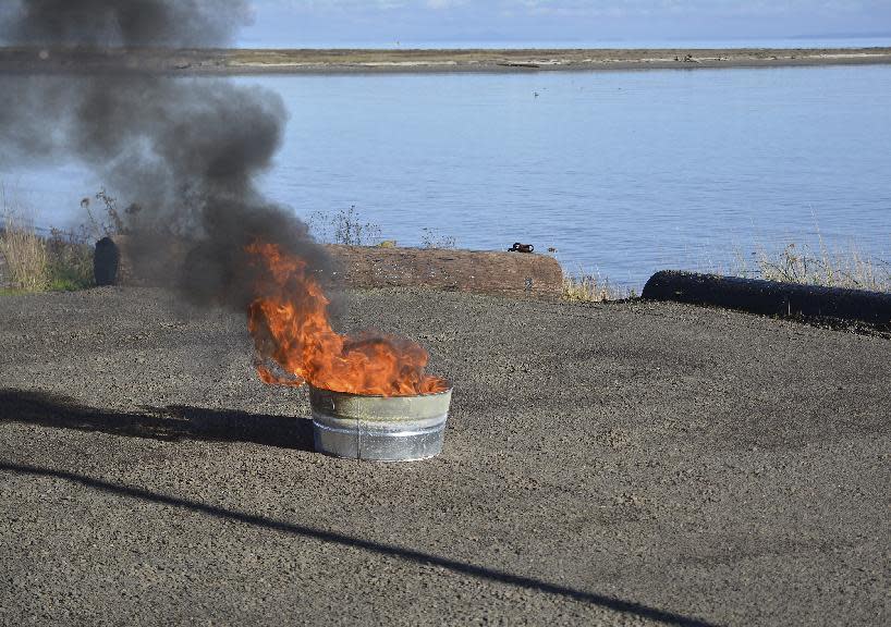 In this Nov. 17, 2016, photo, courtesy of Pacific Northwest National Laboratory, PNNL, shows a controlled oil spill burn at PNNL in Richland, Wash. PNNL scientists have developed its modified sawdust oil spill response material so it can be used in controlled burns, a practice used during the 2010 Deepwater Horizon disaster that can significantly reduce the amount of oil in water and minimize its adverse environmental effects during a demonstration of sawdust oil recovery material research at the PNNL in Richland. (Pacific Northwest National Laboratory via AP)