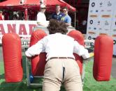 <p>En 2011, à Toronto, pour soutenir la cause du cancer de la prostate, il a tenté de faire bouger le “scrum machine” … ce qui craqua son pantalon ! Crédits : DR </p>