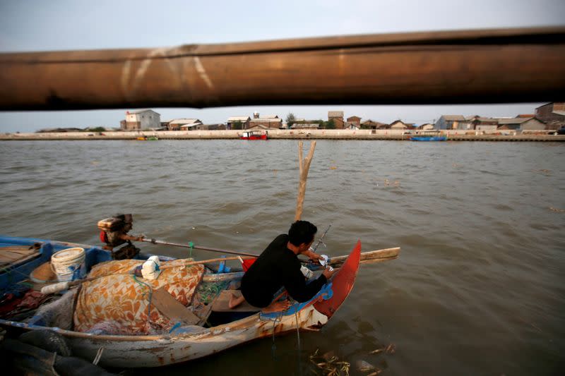 Miskan, a 44-year-old fisherman, prepares his wooden boat before he goes on a fishing trip at Tambaklorok village in Semarang, Central Java province