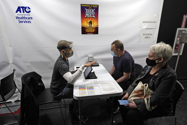 Personas entrevistadas antes de recibir la vacuna de Pfizer para el coronavirus en el ATC Vaccination Services en Times Square, Nueva York (AP Foto/Richard Drew, Pool)