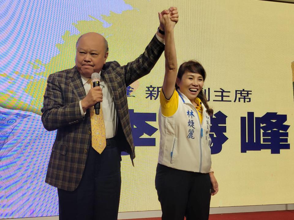 圖片說明：新黨副主席李勝峰高舉林婕麗的手，與台下逾300位支持者齊喊「凍蒜！」。（記者徐煜勝攝）
