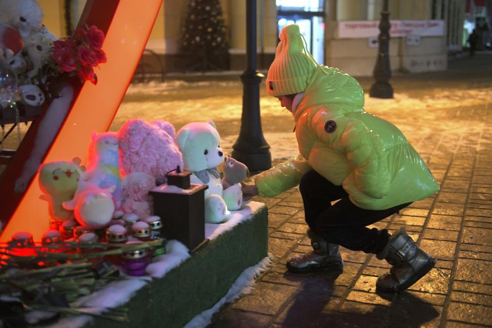 A girl leaves a toy at a makeshift memorial in Belgorod, Russia, on Thursday, Jan. 25, 2024, commemorating victims of a Dec. 30 missile attack by Ukraine that killed 25 and injured 109. Such attacks are dealing a blow to President Vladimir Putin’s attempts to reassure Russians that life in the country is largely untouched by the nearly 2-year-old conflict.. (AP Photo)