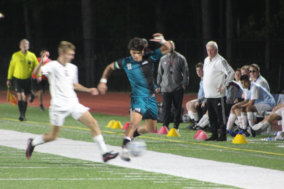 Islands junior Evan Narvaez (right) moves the ball upfield in a win over Benedictine on April 9, 2024.