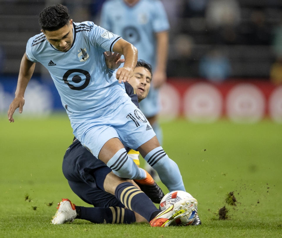 Minnesota United's Emanuel Reynoso (10) is tackled by Philadelphia Union's Alejandro Bedoya during the first half of an MLS soccer match Wednesday, Oct. 20, 2021, in St. Paul, Minn. (Carlos Gonzalez/Star Tribune via AP)