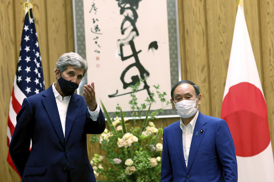 U.S. Special Presidential Envoy for Climate John Kerry, left, gestures to Japanese Prime Minister Yoshihide Suga during a meeting at Suga's official residence in Tokyo Tuesday, Aug. 31, 2021. Kerry met with Japan's top diplomat to push efforts to fight climate change ahead of a United Nations conference in November. (Behrouz Mehri/Pool Photo via AP)