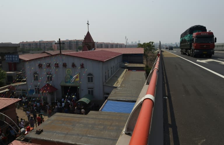 Trucks pass the "underground" Zhongxin Bridge Catholic Church in Tianjin, on May 24, 2014