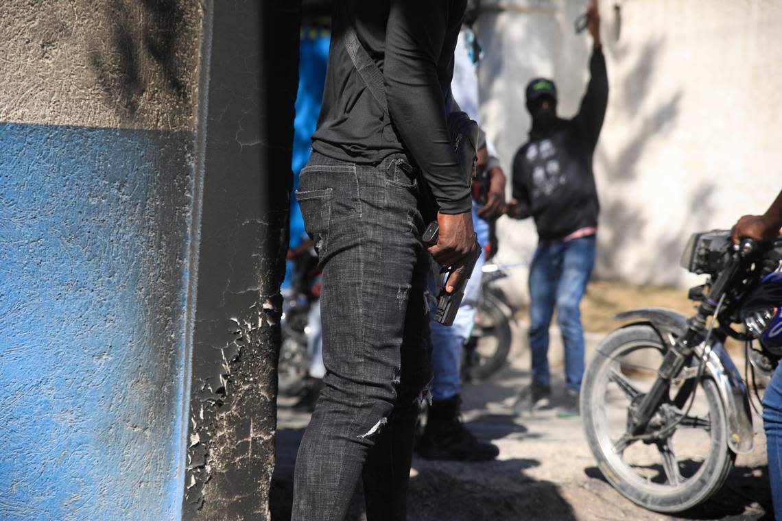 Armed police officers stand with weapons drawn in front of the police headquarters during a protest to denounce bad police governance, in Port-au-Prince, Haiti, Thursday, Jan. 26, 2023.