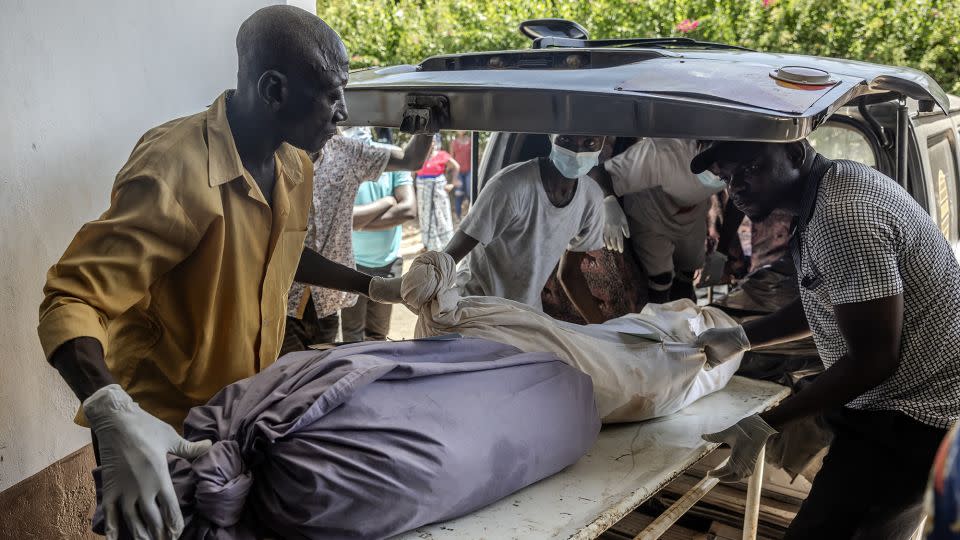 Mortuary workers move the remains of several members of the same family who were victims of the Kenyan starvation cult. - Luis Tato/AFP/Getty Images