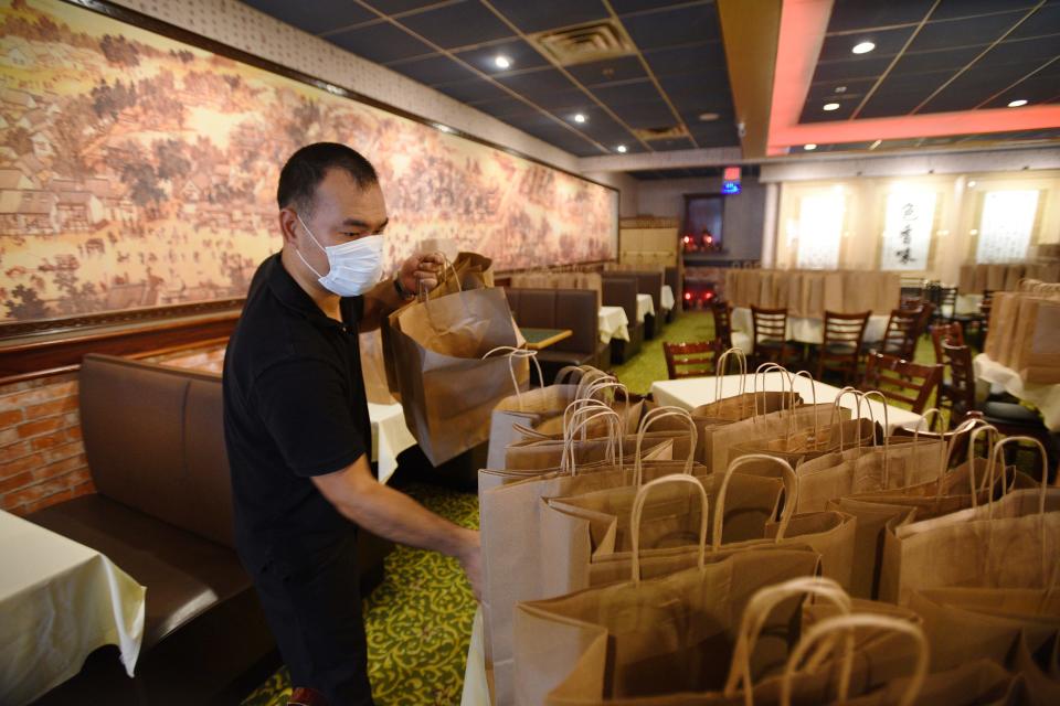 Kevin Lin places paper shopping bags on top of some tables at Cheng Du 23 in Wayne on 09/02/20. Only large supermarkets are banned from using paper bags.