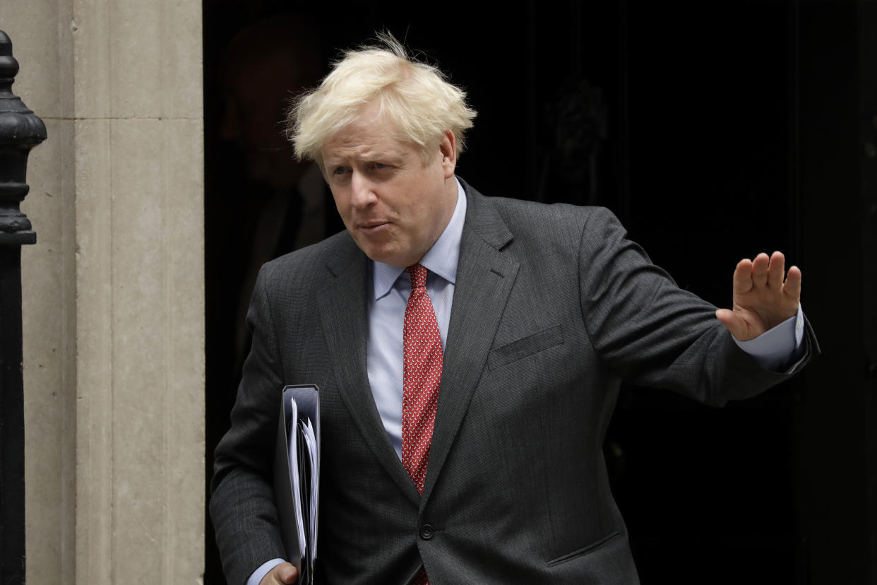 British Prime Minister Boris Johnson waves at the media as he leaves 10 Downing Street, in London, to go to the Houses of Parliament to make a statement on new coronavirus restrictions Tuesday, Sept. 22, 2020. Johnson plans to announce new restrictions on social interactions Tuesday as the government tries to slow the spread of COVID-19 before it spirals out of control. (AP Photo/Matt Dunham)