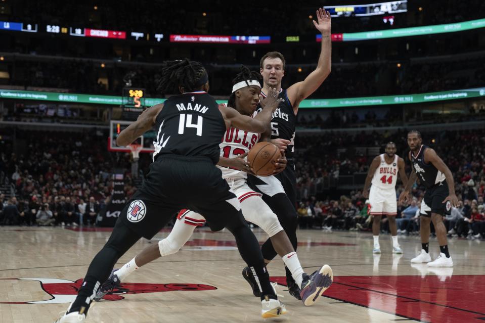 Los Angeles Clippers guard Terance Mann, left, and Clippers guard Luke Kennard, right, guard Chicago Bulls guard Ayo Dosunmu during the first half of an NBA basketball game Tuesday, Jan. 31, 2023, in Chicago. (AP Photo/Erin Hooley)