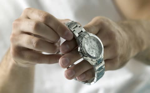 Man putting on silver watch - Credit: Jonathan Bielaski/First Light