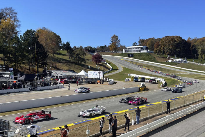 Felipe Nasr, left, of Brazil leads the field to the green flag at the start of the Petit Le Mans auto race, Saturday, Nov. 13, 2021, at Road Atlanta in Braselton, Georgia. The 10-hour race is the IMSA season finale and will decide five class championships. (AP Photo/Jenna Fryer)