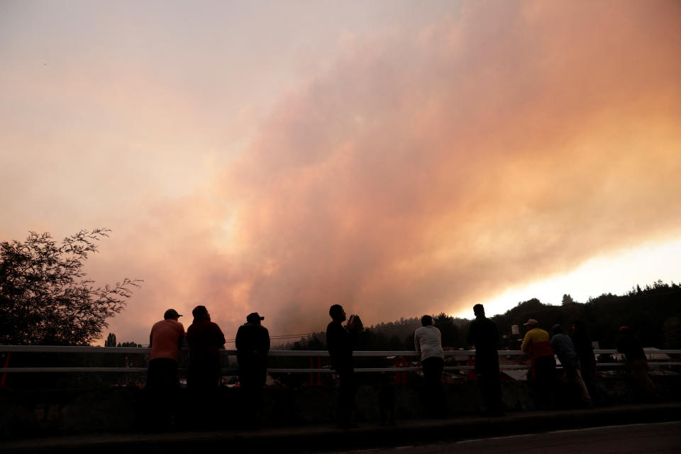 Local residents watch the smoke rise during a forest fire in Rafael, near Concepcion, Chile, February 7, 2023 REUTERS/Juan Gonzalez