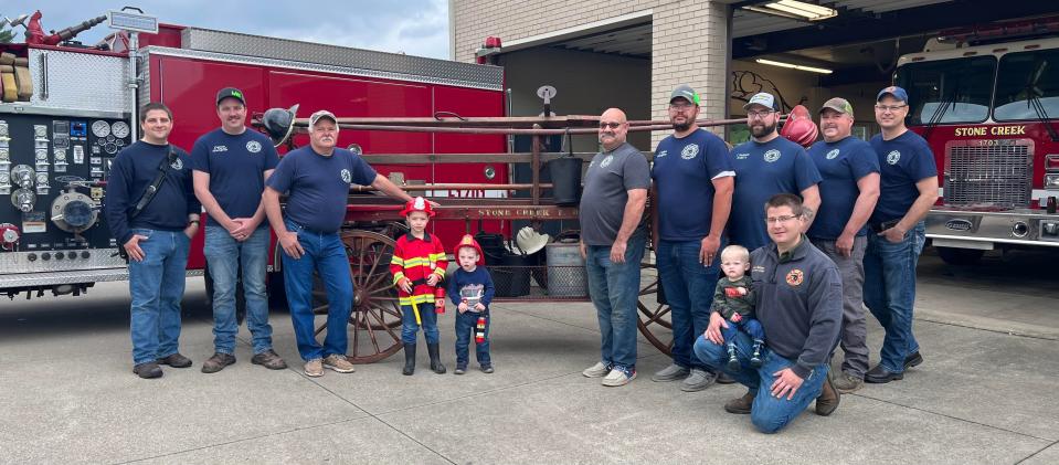Members of the Stone Creek Volunteer Fire Department and some of their children stand in front of the original wagon community members used to fight fires before the formation of the volunteer department. They include, from left, Keith Beitzel, Austin Carter, Darren Prouty, Josiah Beitzel, Micah Beitzel, John McMullen, Christian Deibel, Cody Westhofer, Jeff Cronebaugh, Brian Pfeiffer, and, front, Kevin and Eli Beitzel. Other members include Kevin Yoder, Mike Edwards, Meghan Keiffer, Alan Furner, Austin McMullen, Dana Miller, Ben Miller, and Brandon Elson.