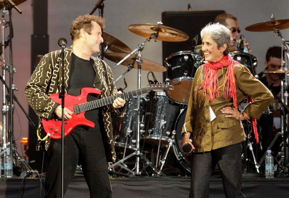 South African musician Johnny Clegg, left, is seen performing with singer Joan Baez at a 2008 London concert celebrating the 90th birthday of Nelson Mandela.