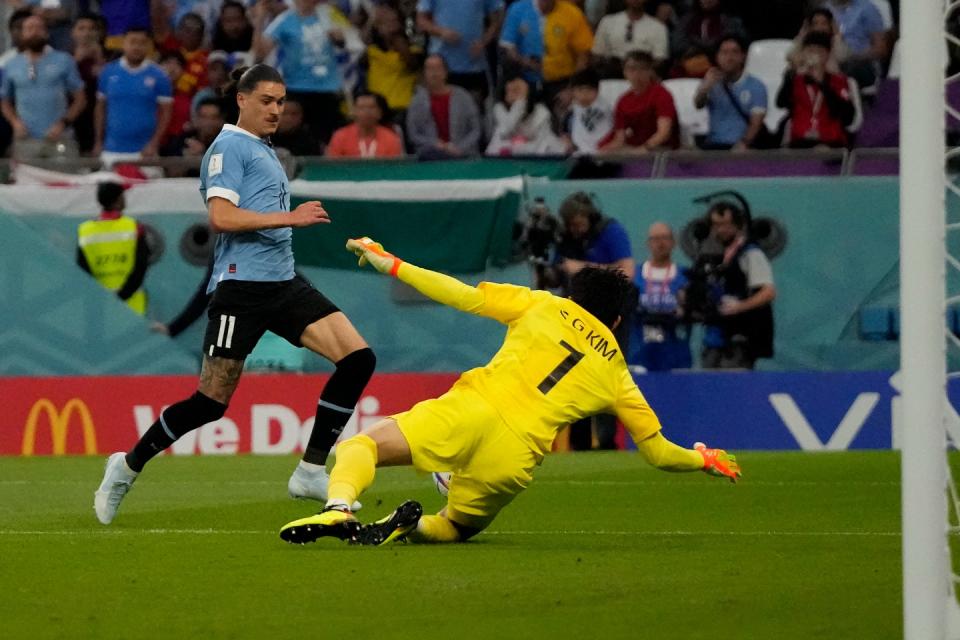 South Korea's goalkeeper Kim Seung-gyu, right, dives to stop the ball after an attempt by Uruguay's Darwin Nunez, left, to score during the World Cup group H football match between Uruguay and South Korea, at the Education City Stadium in Al Rayyan , Qatar, Thursday, Nov. 24, 2022. (AP Photo/Frank Augstein)