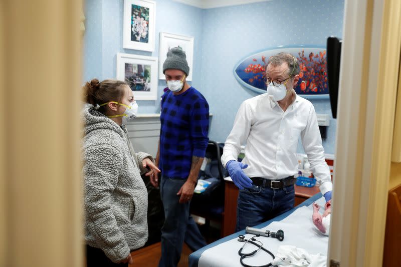 Dr Greg Gulbransen speaks with the parents of a 2-day-old newborn while maintaining visits with both his regular patients and those confirmed to have the coronavirus disease (COVID-19) at his pediatric practice in Oyster Bay, New York