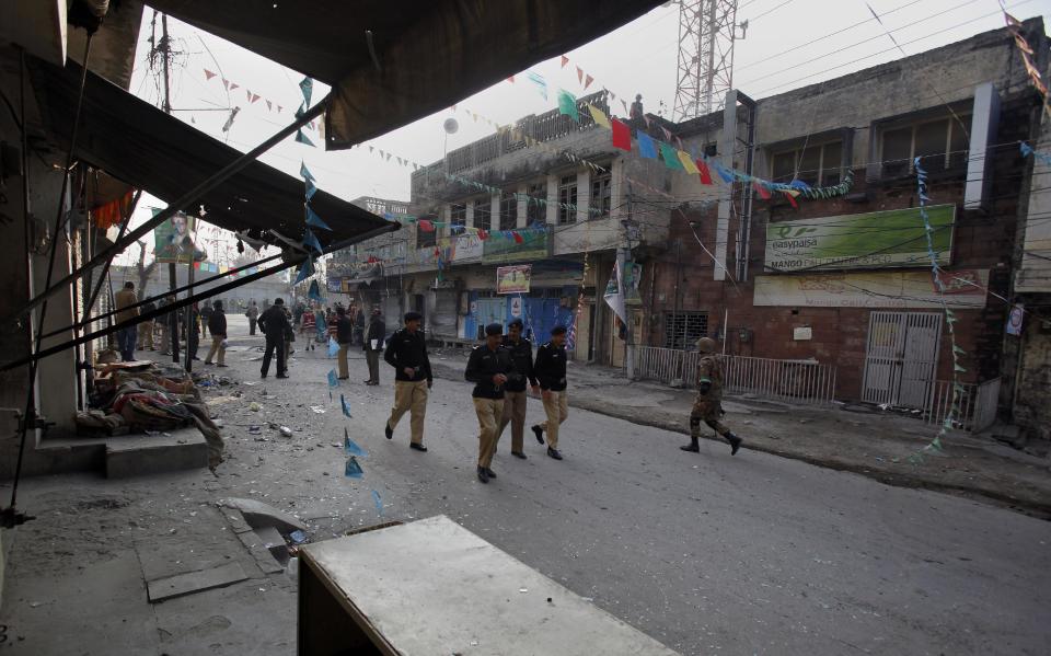 Pakistani security officials examine the site of a suicide bombing in Rawalpindi, Pakistan on Monday, Jan. 20, 2014. A suicide bomber blew himself up not far from Pakistan's military headquarters Monday, killing some people a day after a Taliban bombing inside an army compound in the northwest of the country killed many troops, officials and militants said. (AP Photo/Anjum Naveed)