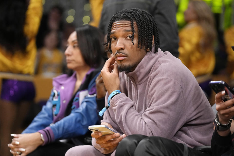 Heisman Memorial Trophy winner, Louisiana State quarterback Jayden Daniels, watches during the second half of an NBA basketball game between the Los Angeles Lakers and the Miami Heat Wednesday, Jan. 3, 2024, in Los Angeles. (AP Photo/Mark J. Terrill)