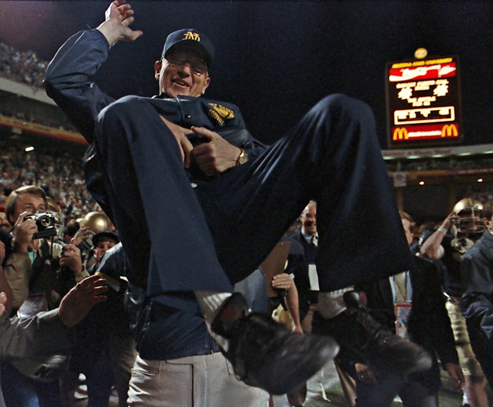 In this Jan 2, 1989 file photo, Notre Dame head coach Lou Holtz is raised up to be carried off the field after Norte Dame defeated West Virginia in the Fiesta Bowl to win the National College championship in Tempe, Ariz. Holtz will be honored with the dedication of a statue at a reunion with about 70 members from that national championship team,  Saturday, Sept. 13, 2008.  The statue depicts him calling a play on the sidelines with two players beside him.