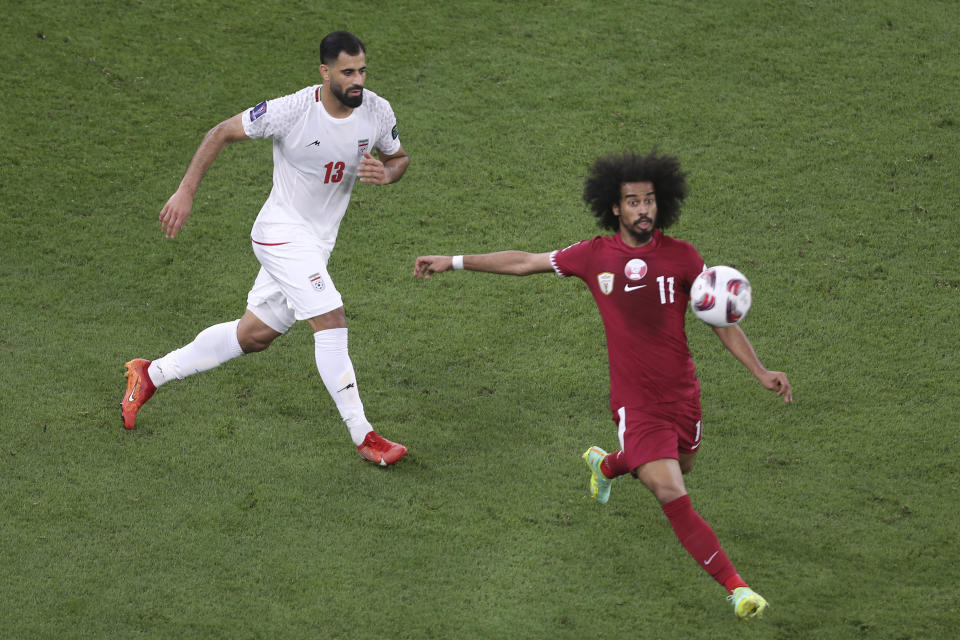 Qatar's Akram Afif, right, compete for the ball with Iran's Hossein Kanani during the Asian Cup semifinal soccer match between Qatar and Iran at Al Thumama Stadium in Doha, Qatar, Wednesday, Feb. 7, 2024. (AP Photo/Hussein Sayed)