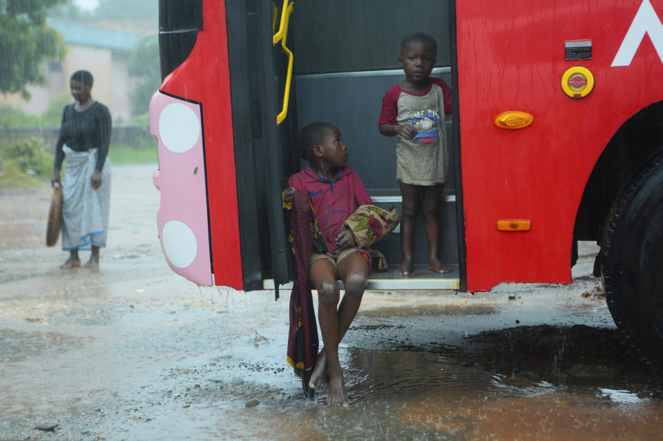 Children seek refugee from the rain, on a bus, in Pemba, on the northeastern coast of Mozambique, Sunday, April, 28, 2019. Serious flooding began on Sunday in parts of northern Mozambique that were hit by Cyclone Kenneth three days ago, with waters waist-high in areas, after the government urged many people to immediately seek higher ground. Hundreds of thousands of people were at risk. (AP Photo/Tsvangirayi Mukwazhi)