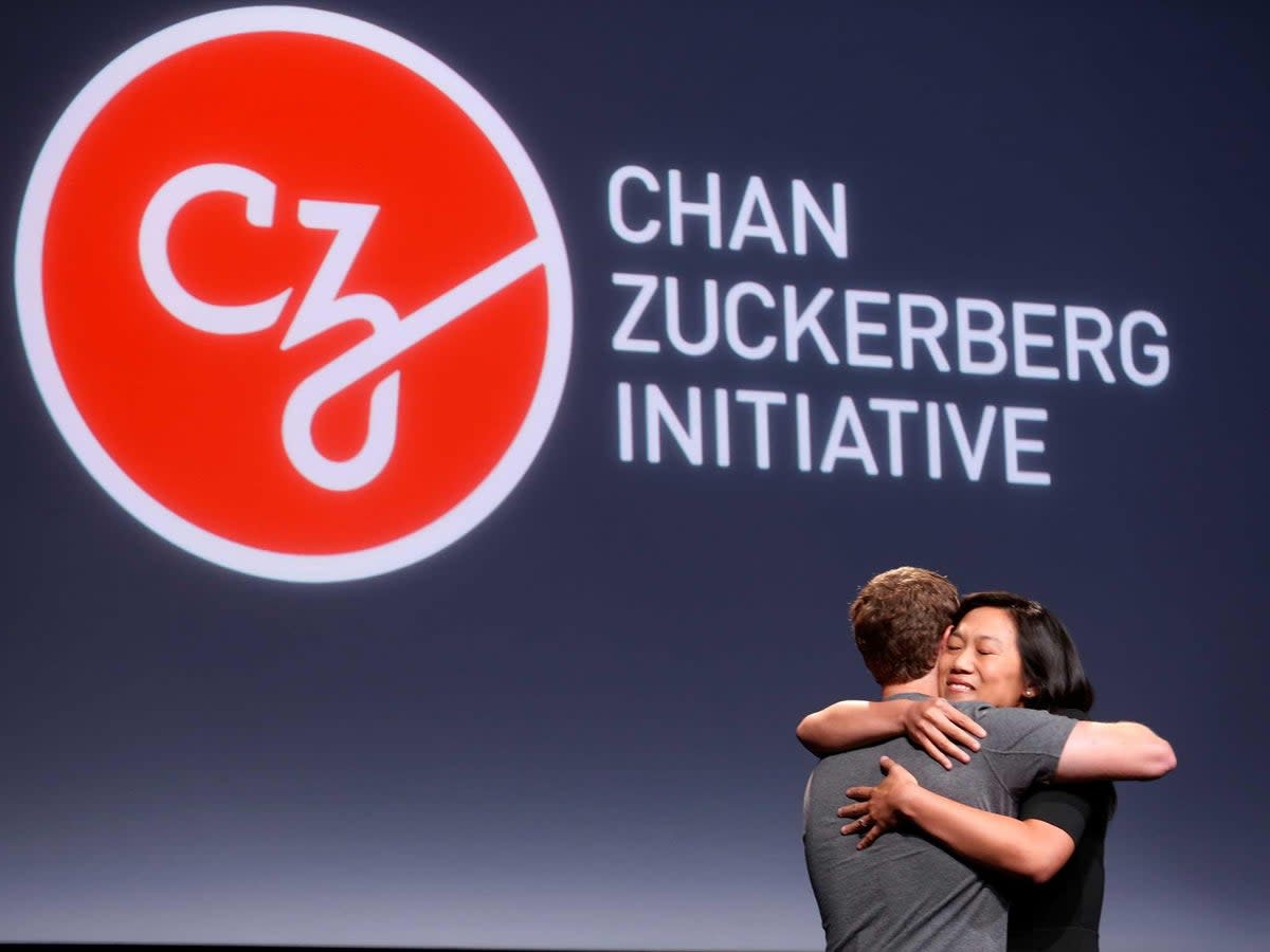 Priscilla Chan (R) embraces her husband Mark Zuckerberg while announcing the Chan Zuckerberg Initiative to 