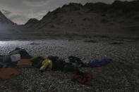 Life jackets, sleeping bags and damaged inflatable small boat are pictured early morning on the shore in Wimereux, northern France, Friday, Nov. 26, 2021 in Calais, northern France. Children and pregnant women were among at least 27 migrants who died when their small boat sank in an attempted crossing of the English Channel, a French government official said Thursday. (AP Photo/Rafael Yaghobzadeh)