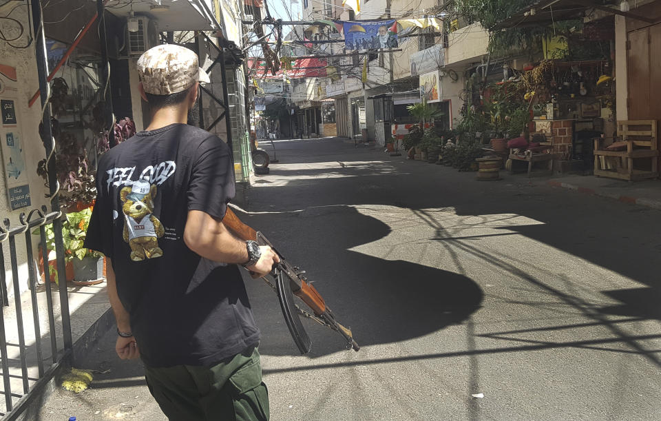 A fighter of the Palestinian Fatah group crosses a street during clashes with Islamist militants in the Palestinian refugee camp of Ein el-Hilweh near the southern port city of Sidon, Friday, Sept. 8, 2023. Clashes resumed in Lebanon's largest Palestinian refugee camp overnight, with heavy gunfire and shelling wounding more than a dozen of people and prompting residents of the camp and the surrounding area to flee on Friday. (AP Photo/Mohammed Zaatari)