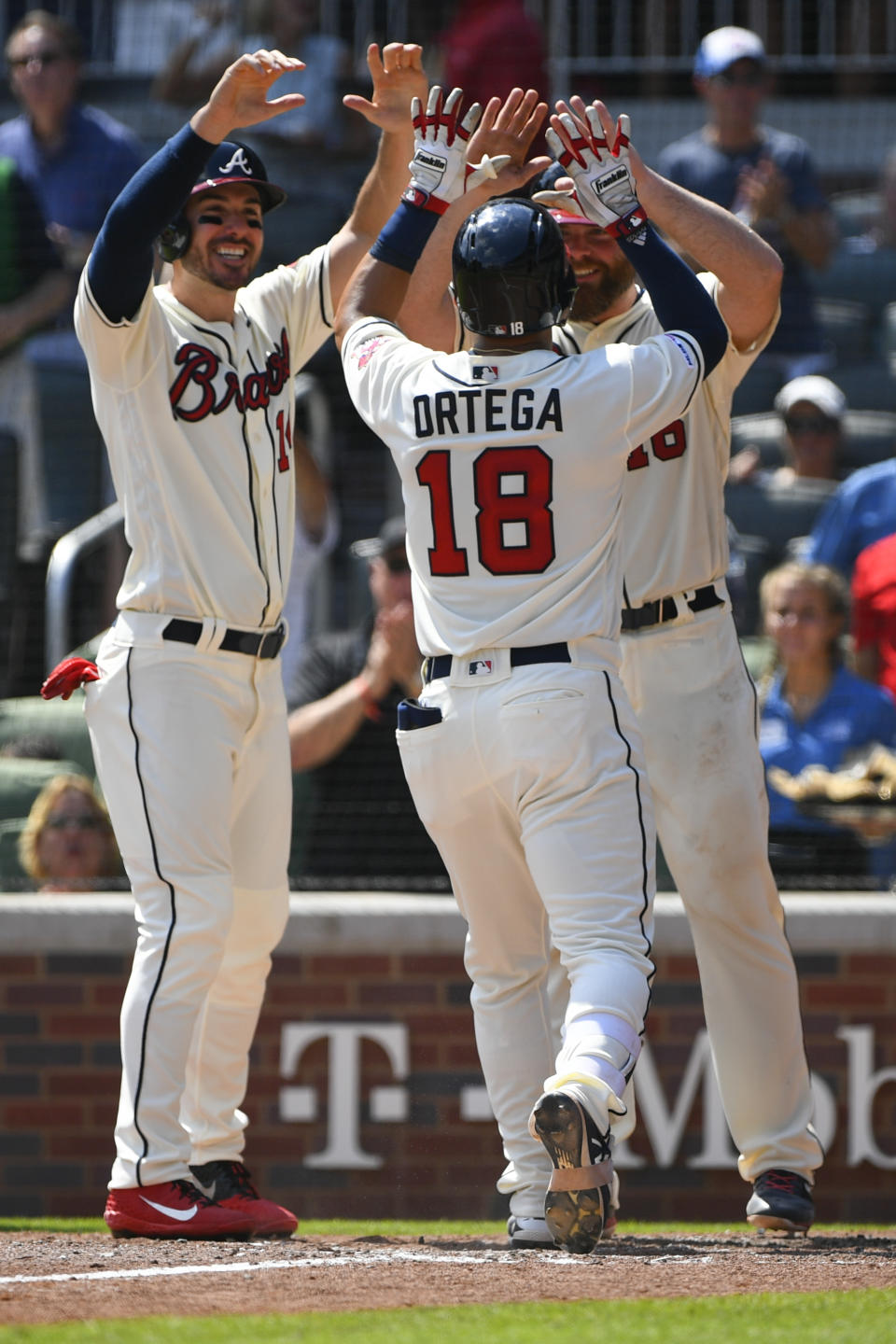 Atlanta Braves' Rafael Ortega (18) celebrates at home plate with Atlanta Braves' Matt Joyce, left, and Brian McCann after hitting a grand slam home run against the Los Angeles Dodgers during the sixth inning of a baseball game Sunday, Aug. 18, 2019, in Atlanta. (AP Photo/John Amis)