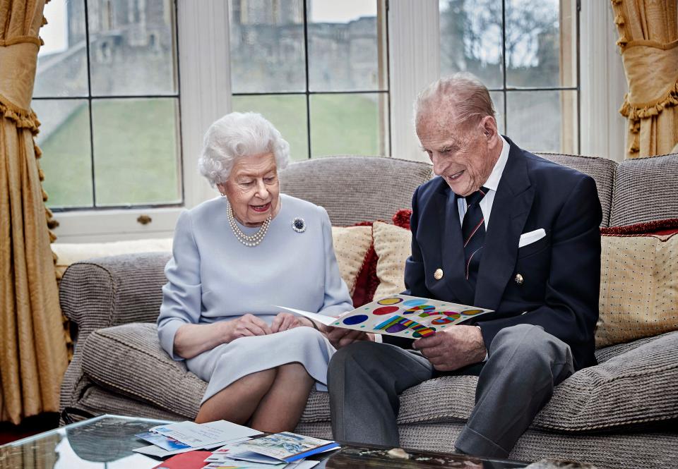 Queen Elizabeth II and Prince Philip, Duke of Edinburgh, look at homemade wedding anniversary cards given to them by their great-grandchildren at Windsor Castle ahead of their 73rd anniversary, Nov. 17, 2020.