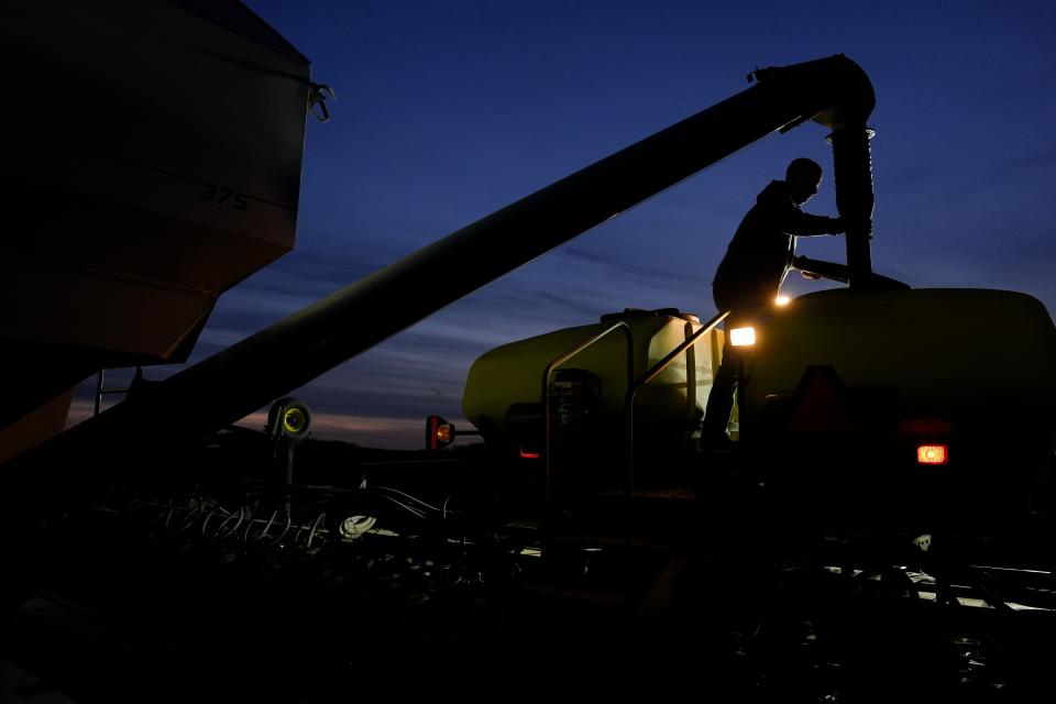 Mark Woodruff loads more soybean seeds into a planter, Monday, April 22, 2024, in Sabina, Ohio. When farmers have to wait for fields to dry out, already long planting days can become endurance tests that stretch into the night. (AP Photo/Joshua A. Bickel)