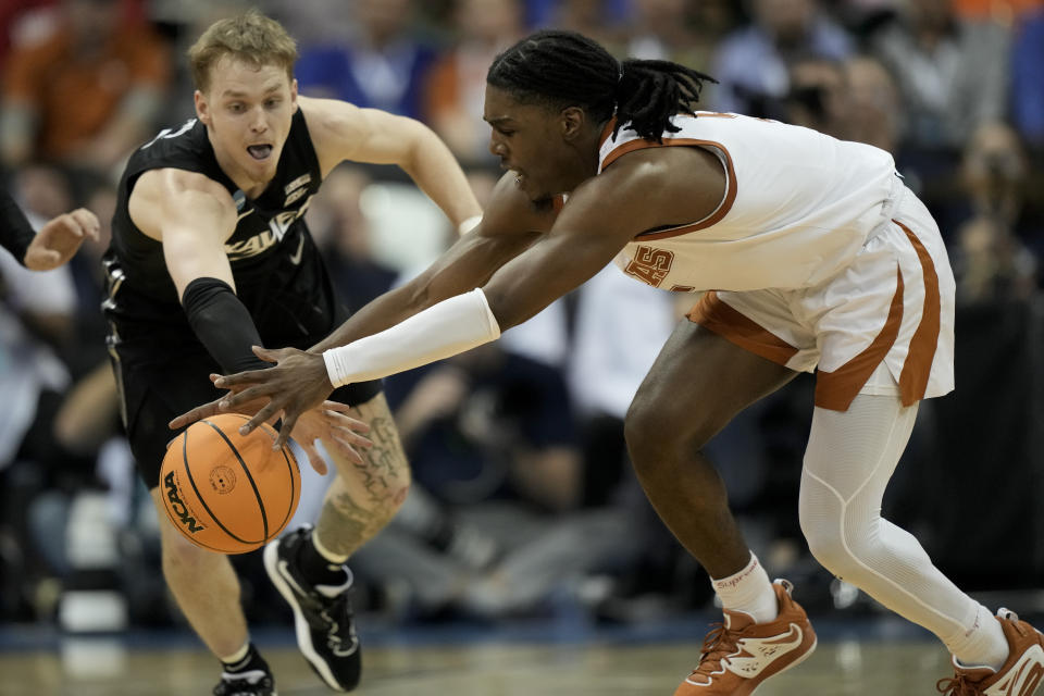 Xavier guard Adam Kunkel vies for the ball with Texas guard Marcus Carr in the first half of a Sweet 16 college basketball game in the Midwest Regional of the NCAA Tournament Friday, March 24, 2023, in Kansas City, Mo. (AP Photo/Charlie Riedel)