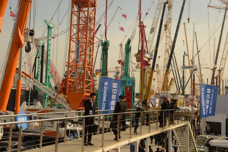 Visitors look at construction machinery at the Bauma China 2012 International Trade Fair in Shanghai on November 28, 2012. Foreign direct investment in China declined for the first time in three years in 2012, official data shows, amid economic turmoil in developed markets and a slowdown at home