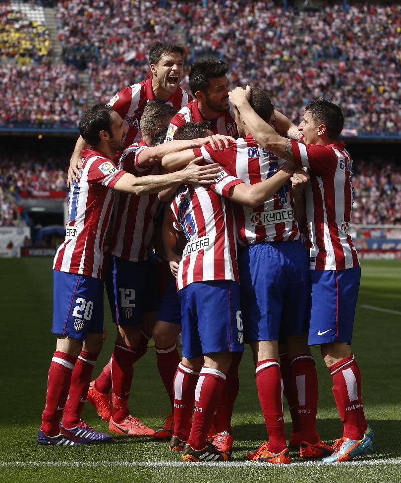 Atletico's Raul Garcia, second left, partly seen, celebrates his goal with teammates during a Spanish La Liga soccer match between Atletico Madrid and Villarreal at the Vicente Calderon stadium in Madrid, Spain, Saturday, April 5, 2014. (AP Photo/Andres Kudacki)