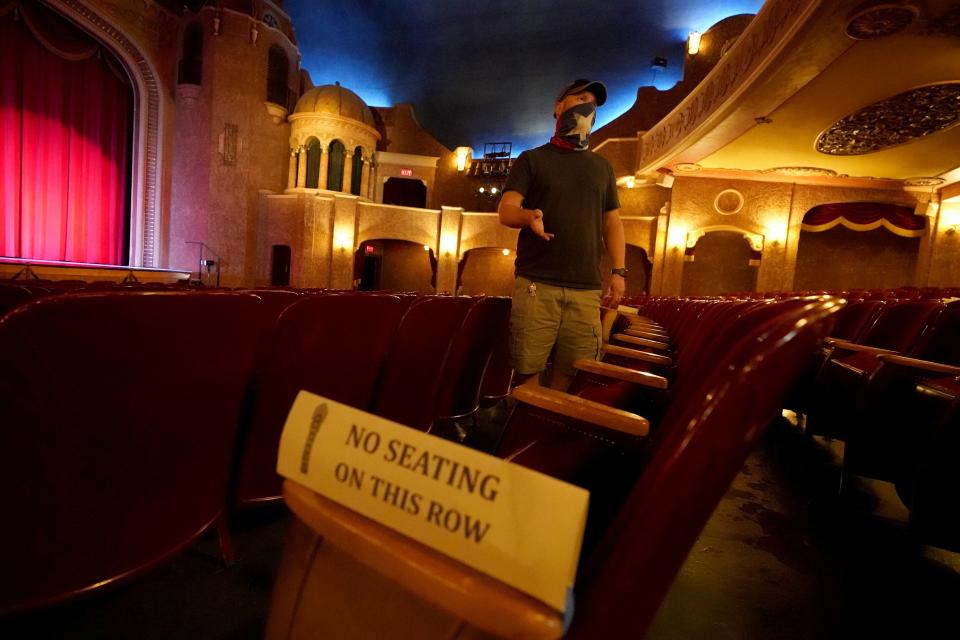 Employee Grayson Allred responds to questions from a reporter while standing inside the Paramount Theatre on Wednesday, Dec. 16, 2020, in Abilene, Texas. The theatre has closed down indefinitely due to rising cases of COVID-19 in the city. (AP Photo/Tony Gutierrez)