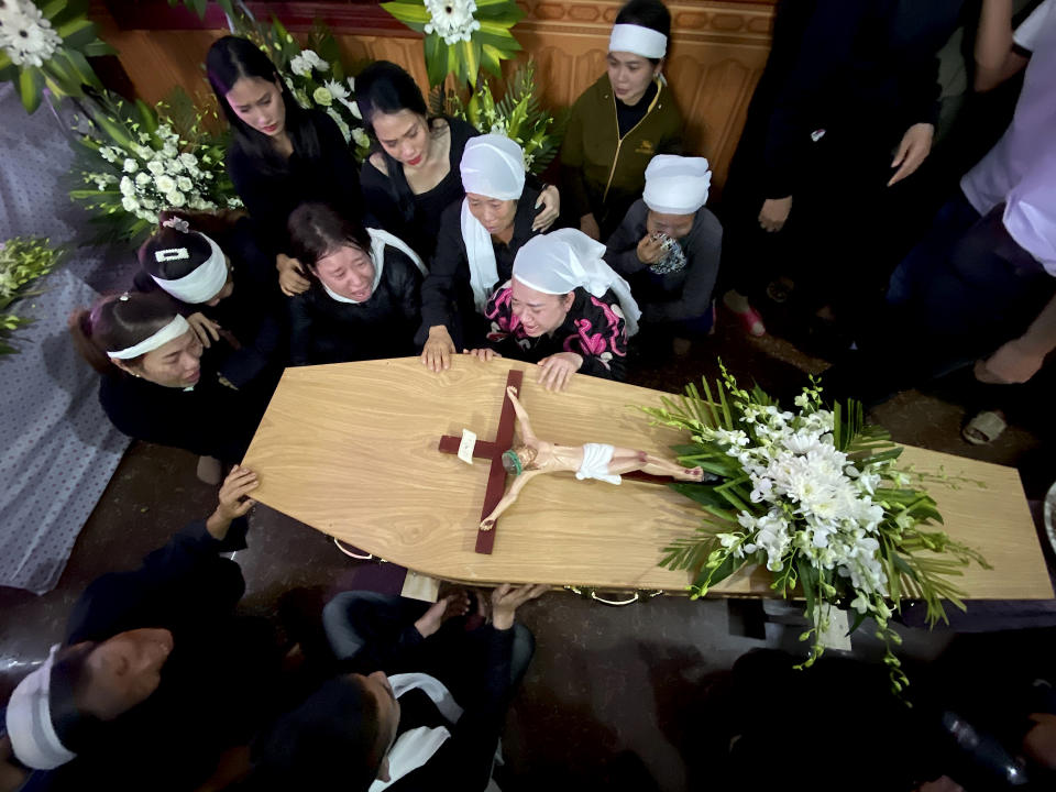 Relatives of Bui Thi Nhung weep as they gather around Nhung's casket at the family home on Saturday, Nov. 30, 2019 in the village of Do Thanh, Vietnam. The body of 19-year old Nhung was among the last remains of the 39 Vietnamese who died while being smuggled in a truck to England last month that were repatriated to their home country on Saturday.(AP Photo/Hau Dinh)