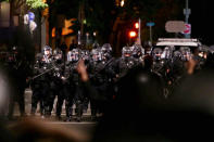 Portland police clash with protesters during a demonstration in downtown Portland, early Thursday, Aug. 13, 2020. The demonstration lasted into the predawn hours of Thursday, with some in the crowd setting a fire and exploding commercial grade fireworks outside a federal courthouse that's been a target in months of conflict for Oregon's largest city. (Sean Meagher/The Oregonian via AP)