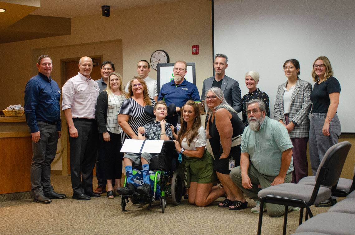 Pasco School Board members, family, teachers and district staff pose for a photo with Gabe Scheel, a Ray Reynolds Middle School special education student.